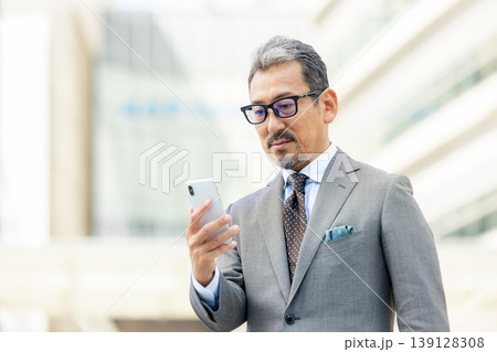 スマートフォンを操作するシニア男性 スマートフォンを操作するシニア男性 139128308