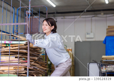 倉庫　ダンボールカートを運ぶ女性 139128319