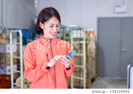 倉庫　スマホを見ている女性 139128491
