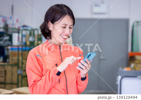 倉庫　スマホを見ている女性 139128494
