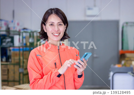 倉庫　スマホを見ている女性 139128495