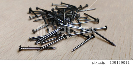 Pile of Iron Nails on Wooden Surface 139129011