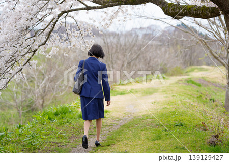 桜の下をうなだれて歩くスーツ姿の女性の後姿 桜の下をうなだれて歩くスーツ姿の女性の後姿 139129427