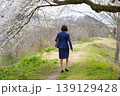 桜の下をうなだれて歩くスーツ姿の女性の後姿 139129428