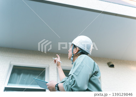 ベランダ下の軒天を点検する業者 139129846