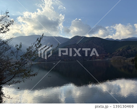 湖畔の風景・山並みを照らす光と雲・冬の静かな湖面・神秘的な自然背景・コピースペース 139130469