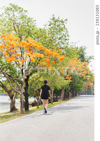 Woman exercise takes a peaceful walk in a park. 139131065