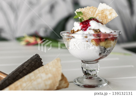 gelato ice cream and mixed fruit sundae dessert in glass cup on outdoor cafe white table gelato ice cream and mixed fruit sundae dessert in glass cup on outdoor cafe white table 139132131