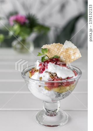 gelato ice cream and mixed fruit sundae dessert in glass cup on outdoor cafe white table gelato ice cream and mixed fruit sundae dessert in glass cup on outdoor cafe white table 139132133