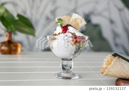 gelato ice cream and mixed fruit sundae dessert in glass cup on outdoor cafe white table gelato ice cream and mixed fruit sundae dessert in glass cup on outdoor cafe white table 139132137