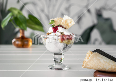 gelato ice cream and mixed fruit sundae dessert in glass cup on outdoor cafe white table gelato ice cream and mixed fruit sundae dessert in glass cup on outdoor cafe white table 139132138
