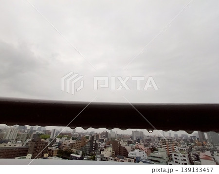雨の日の非常階段とぼやけた街並み　鉄柵の質感 139133457