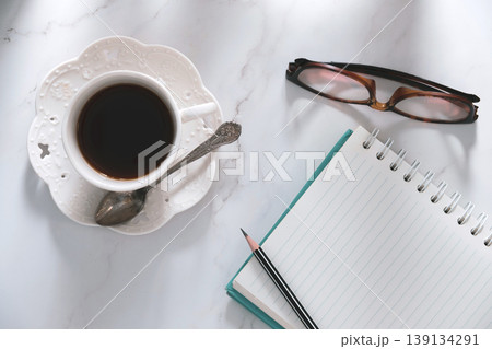 top table view of coffee, notebook, goggles and pencil, a creative breakfast journaling idea. top table view of coffee, notebook, goggles and pencil, a creative breakfast journaling idea. 139134291