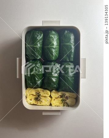 Bento or dosirak box filled with rice, assorted side dishes, vegetables, and protein like meat or fish, all neatly arranged to create a balanced, colorful, and visually appealing meal 139134305
