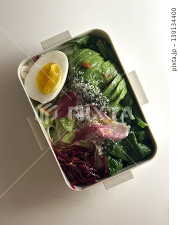 Bento or dosirak box filled with rice, assorted side dishes, vegetables, and protein like meat or fish, all neatly arranged to create a balanced, colorful, and visually appealing meal 139134400