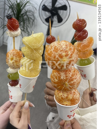 Tanghulu, a traditional Chinese snack made of skewered fruits, usually covered in a shiny sugar coating. Sweet and crunchy, this street food treat is a delightful combination of flavors and textures. 139134563