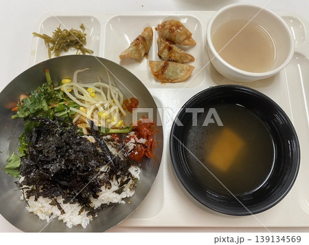 Bibimbap, a vibrant Korean rice dish topped with a variety of seasoned vegetables, gochujang, and a fried egg, often accompanied by sliced meat. Mixed together, it creates a flavorful and balanced. 139134569