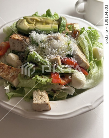 Fresh salad with a mix of crisp leafy greens, sliced vegetables, and colorful ingredients, tossed together to create a healthy, vibrant, and refreshing dish full of natural flavors Fresh salad with a mix of crisp leafy greens, sliced vegetables, and colorful ingredients, tossed together to create a healthy, vibrant, and refreshing dish full of natural flavors 139134603