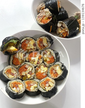 Delicious kimbap rolls filled with fresh vegetables, seasoned rice, and savory proteins, all wrapped in crisp seaweed. A perfect combination of flavor and texture in every bite. Delicious kimbap rolls filled with fresh vegetables, seasoned rice, and savory proteins, all wrapped in crisp seaweed. A perfect combination of flavor and texture in every bite. 139134676