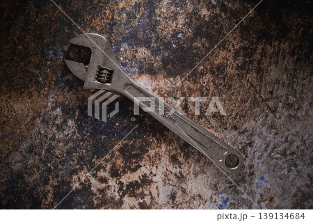 Adjustable wrench hand tools on a dark rusty metal background. Adjustable wrench hand tools on a dark rusty metal background. 139134684