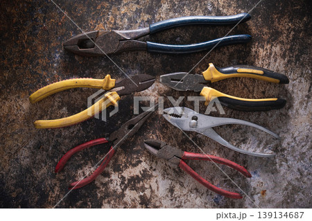 Various professional pliers and hand tools on rustic industrial background. Various professional pliers and hand tools on rustic industrial background. 139134687