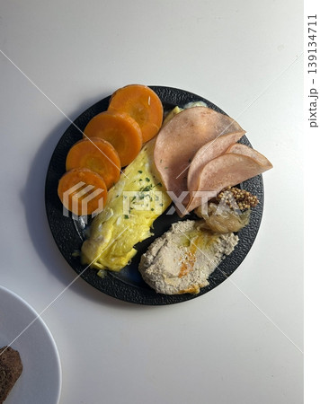 A delightful brunch spread featuring a mix of savory and sweet dishes, including fresh pastries, eggs, seasonal fruits, and a hot beverage. A perfect mid-morning indulgence. 139134711