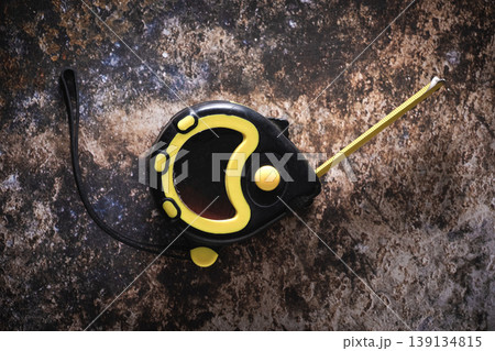 Yellow measuring tape on dark rusty metal background - Precision measurement concept. 139134815