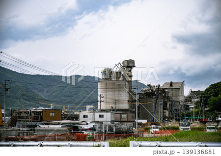 山並みを背景に稼働する巨大なセメント工場のプラントと建設現場 山並みを背景に稼働する巨大なセメント工場のプラントと建設現場 139136881