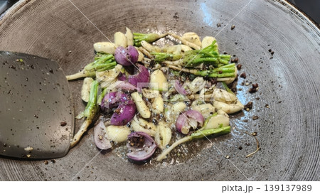Sauteing Garlic, Shallots, and Cilantro Roots with Black Pepper in a Metal Wok Sauteing Garlic, Shallots, and Cilantro Roots with Black Pepper in a Metal Wok 139137989