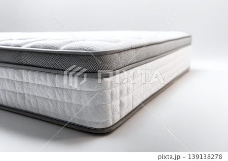Mattress against white background. Memory foam mattress. Close up white orthopedic mattress corner, copy space for text. Hypoallergenic bed base for proper spinal alignment and pressure point relief. Mattress against white background. Memory foam mattress. Close up white orthopedic mattress corner, copy space for text. Hypoallergenic bed base for proper spinal alignment and pressure point relief. 139138278