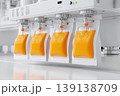 Industrial juice filling line automation sterile. Clear plastic bottles travel on conveyor under precision nozzles. Vibrant orange liquid flows into containers. Modern juice bottling sealing equipment 139138709