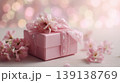 Beautiful pink flowers and wrapped gift box. Soft, celebratory atmosphere, bokeh lights in the background. Banner with space for text. Elegant giftbox. Spring holiday mood. Pastel colored dreamy glow. 139138769