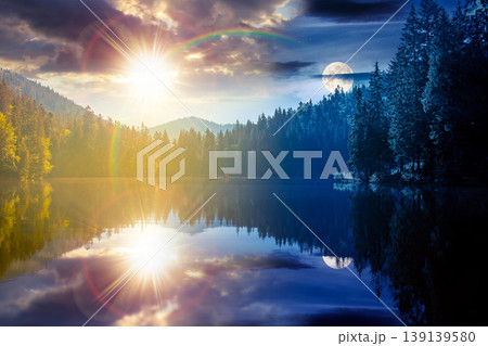day meet night on quiet lake. sun and moon over coniferous forest reflecting on the calm body of water. epic place in national park. summer nature background image for astrology wallpaper concept 139139580
