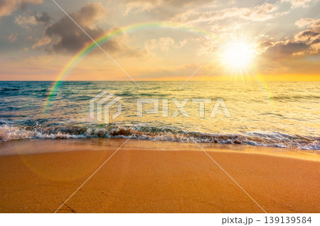 sunset over autumn vacation at the sea. beautiful seascape under rainbow. calm waves wash the sandy beach. image with cloudy sky above horizon. background for nostalgia or ads placement sunset over autumn vacation at the sea. beautiful seascape under rainbow. calm waves wash the sandy beach. image with cloudy sky above horizon. background for nostalgia or ads placement 139139584