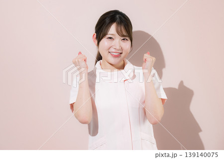 ピンク背景でガッツポーズの看護師さんのイメージ カメラ目線の笑顔 転職成功などのポーズ ピンク背景でガッツポーズの看護師さんのイメージ カメラ目線の笑顔 転職成功などのポーズ 139140075