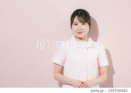 ピンク背景で看護師さんのイメージ カメラ目線の笑顔 ピンク背景で看護師さんのイメージ カメラ目線の笑顔 139140082
