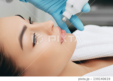 woman gets rejuvenation and hydration of her skin with help without no-needle mesotherapy 139140619