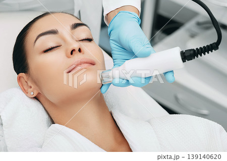 woman receiving no-needle high frequency mesotherapy at beauty salon. non-invasive procedure for skin rejuvenation 139140620