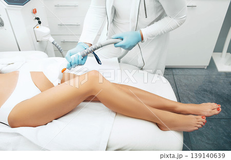 Laser hair removal on beautiful female legs. Laser cosmetologist doing legs smooth and hair free. 139140639
