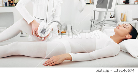 Beautician doing lpg massage procedure in the spa. Woman's legs will be beautiful and without cellulite 139140674