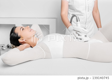 Beautiful woman receiving lpg massage against cellulite on belly 139140745