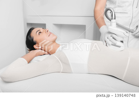 Beautiful woman receiving lpg massage against cellulite on belly 139140748