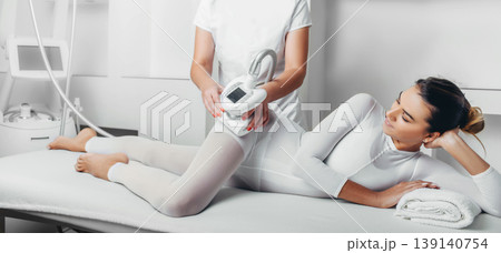 Beautiful woman having LPG massage for removing cellulite on body. cellulite treatment at beauty clinic Beautiful woman having LPG massage for removing cellulite on body. cellulite treatment at beauty clinic 139140754