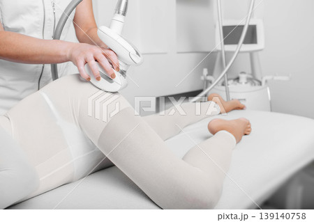 beautician doing lpg massage against cellulite on female leg beautician doing lpg massage against cellulite on female leg 139140758