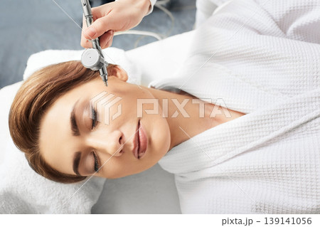 Jet peeling skin renewal procedure. Cropped woman's face with eye close while jet peel procedure 139141056