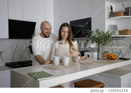 Smiling couple drinking tea at home kitchen Smiling couple drinking tea at home kitchen 139141219