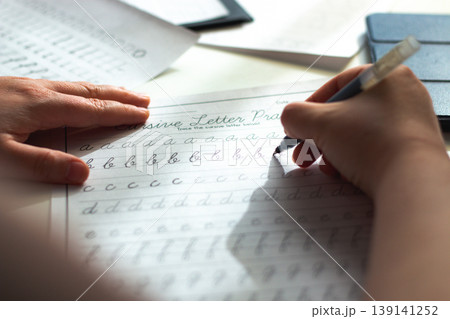 Quiet scene of woman writing with pen. Training accurate handwriting. Therapeutic habit to reduce anxiety and increase clarity. Calmness and digital detox 139141252