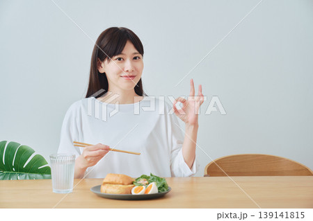 食事を楽しみながらOKサインを出す女性 満足感のある朝食シーン 食事を楽しみながらOKサインを出す女性 満足感のある朝食シーン 139141815