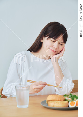 朝食中に体調の違和感を感じる女性 食欲不振のイメージ 139141852
