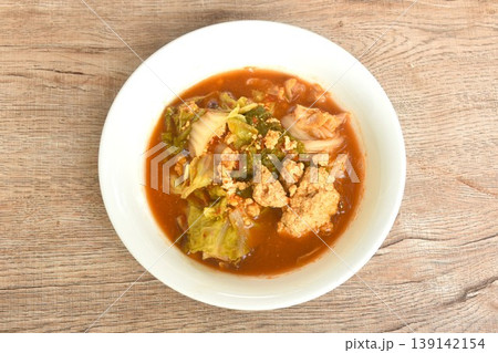 boiled mixed vegetable and fish egg in Thai spicy curry soup on bowl 139142154